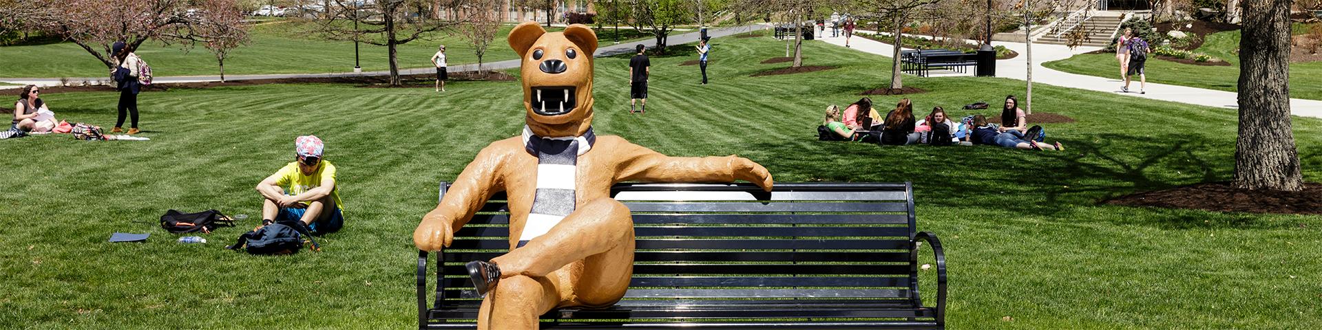 宾州州立银行 Lion Bench with students sitting in the grass