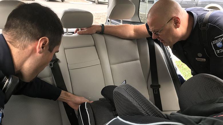 officers inspect child safety seat