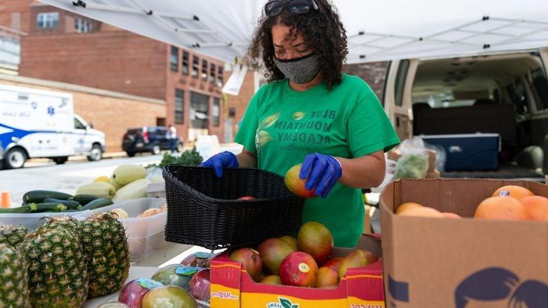 克里斯蒂娜休斯顿, 蓝山学院的工作人员, 安排农产品在宾夕法尼亚州立健康街的农场摊位上出售. 约瑟夫市区校区.